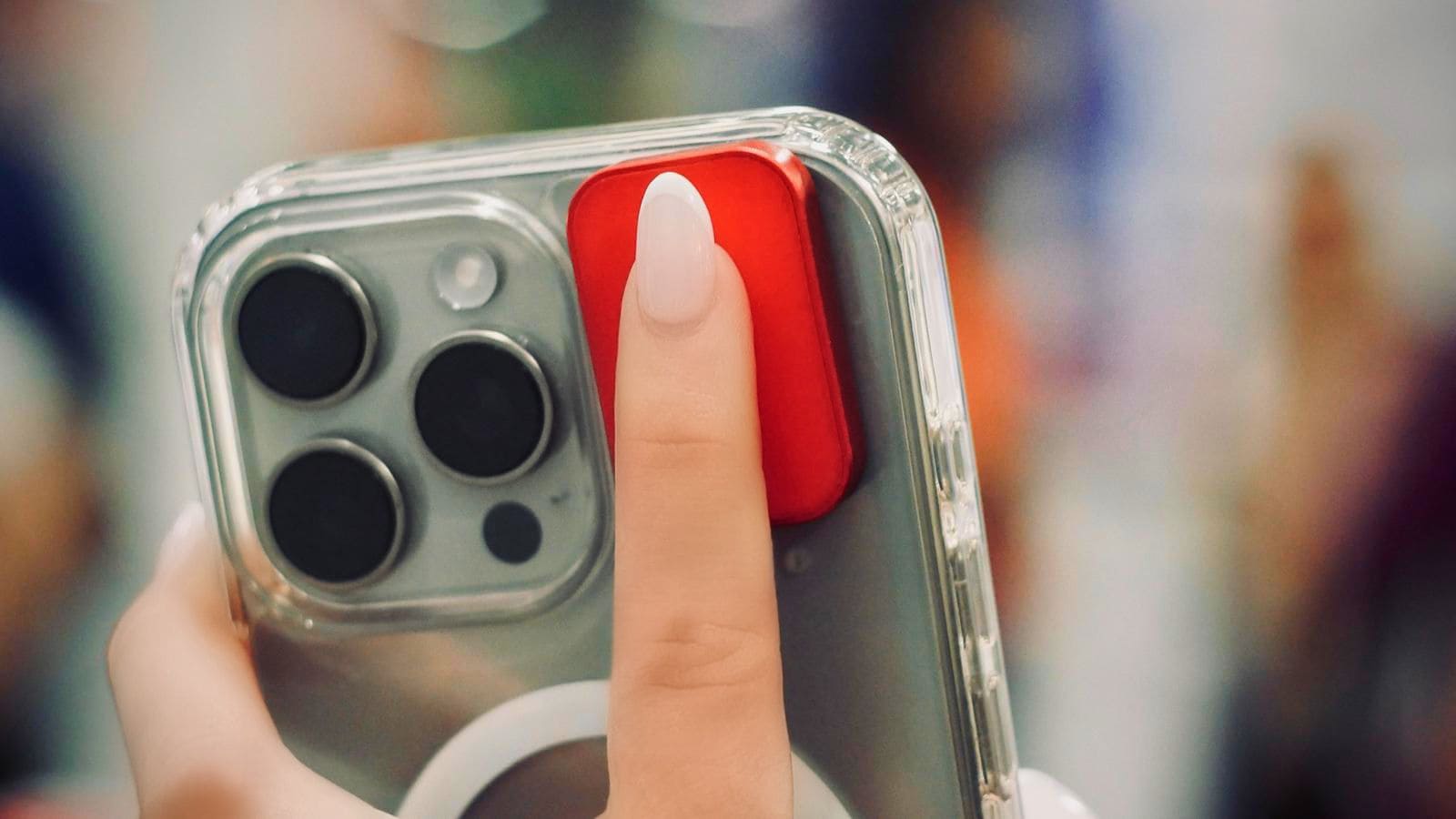 A finger pressing the red Solver button on the back of an iPhone